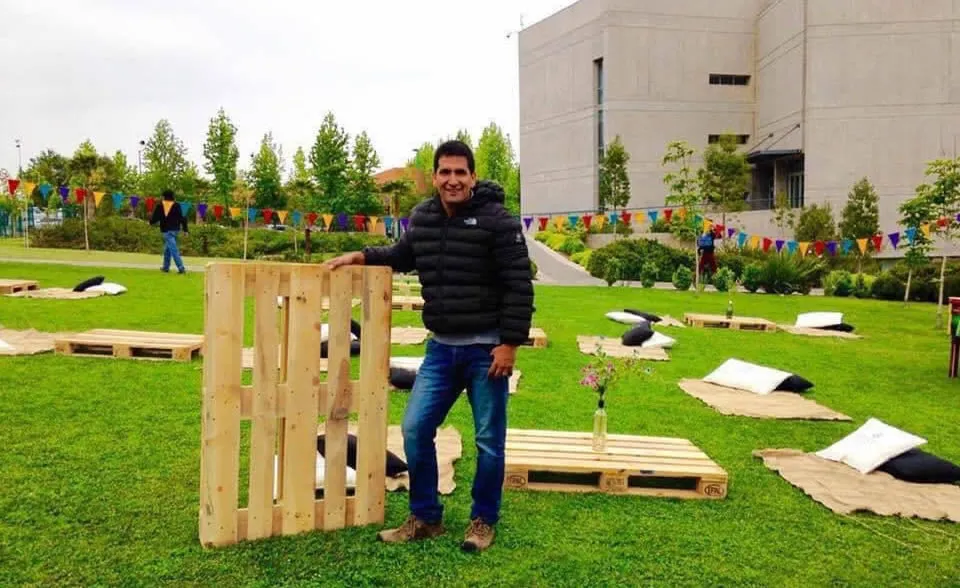 Fernando Villalobos junto a pallets de madera